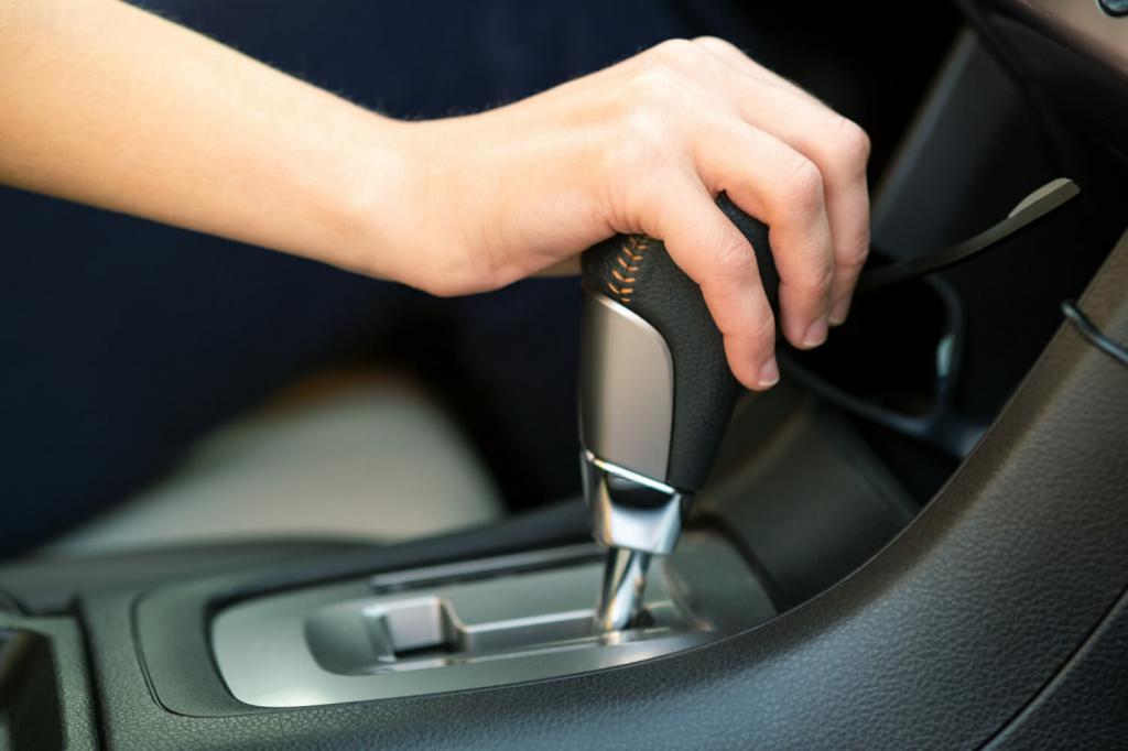close-up-woman-driver-holding-her-hand-automatic-gear-shift-stick-driving-as-car.jpg