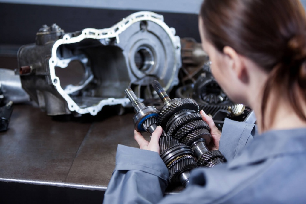 female-mechanic-holding-spare-parts-car.jpg