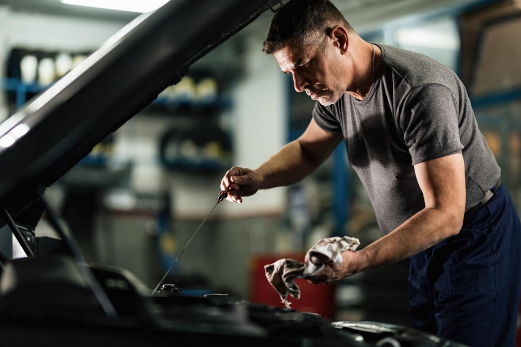 mid-adult-mechanic-examining-car-oil-auto-repair-shop.jpg